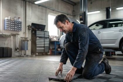 Mécanicien auto en train de poser des carreaux dans un garage