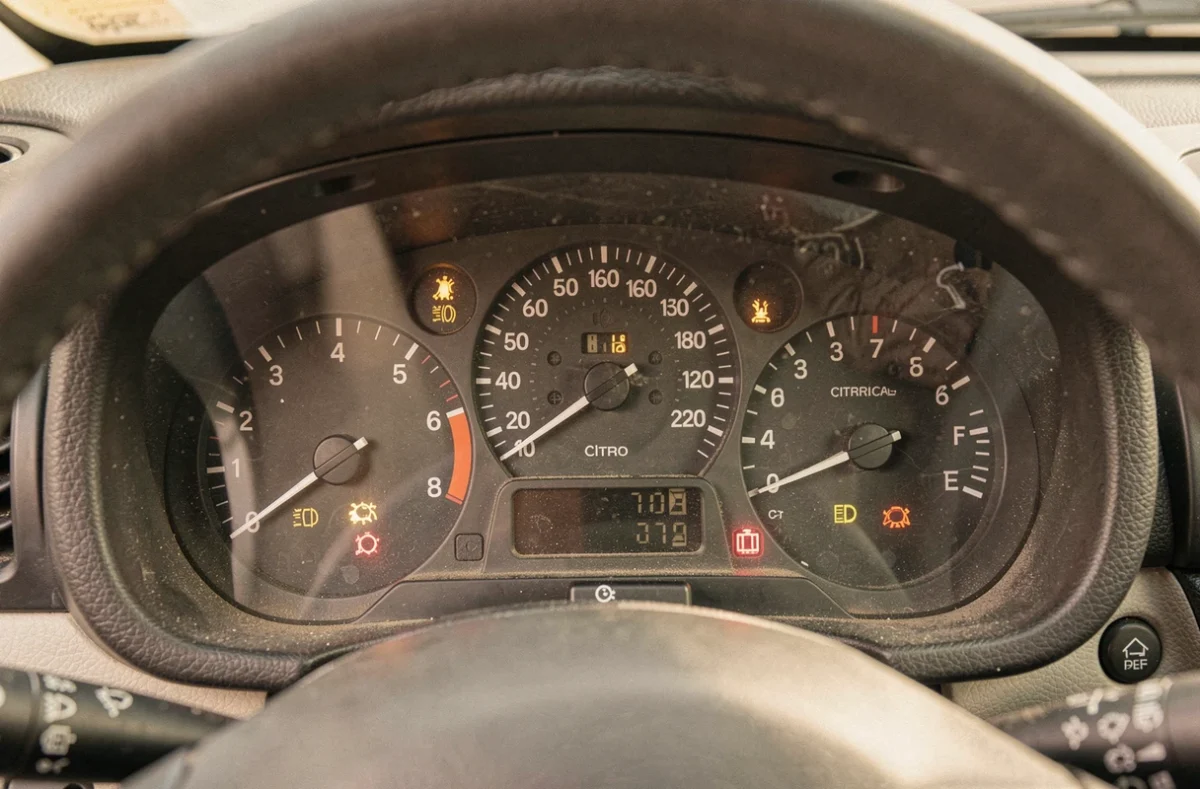 Voyants du tableau de bord d'une ancienne Citroën C3 avec témoins lumineux allumés sur le combiné d'instruments analogique